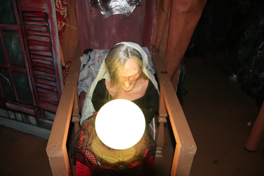 A witch peers into her crystal ball inside Reinke Brothers' haunted mansion.